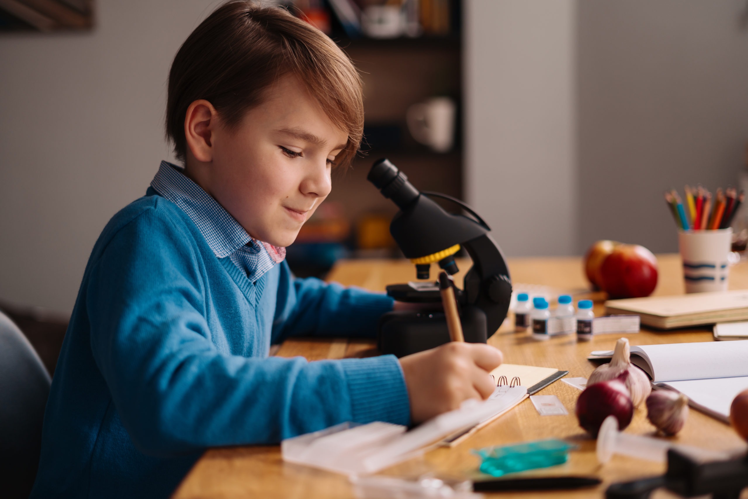 Chłopiec uczący się przy mikroskopie