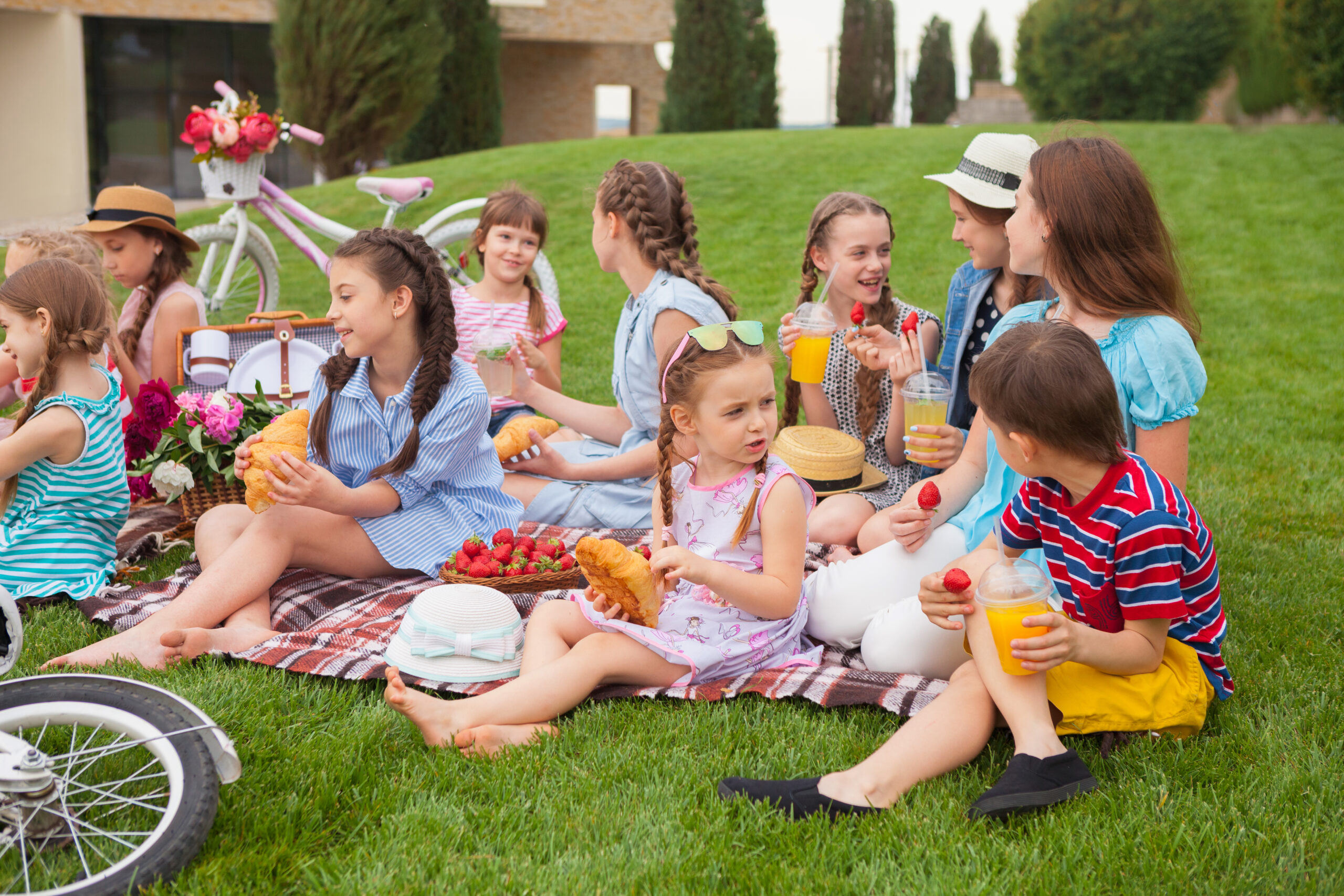 szczęśliwe dzieci siedzące na kocu na pikniku